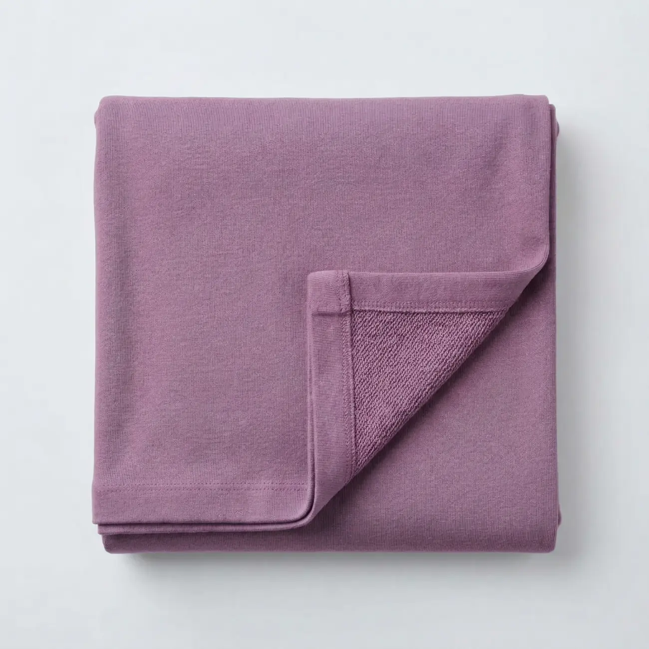 Flach liegender, quadratisch gefalteter Stoff in einem warmen, Violettton. Die glatte, weiche Textur eignet sich perfekt als Meterware zum Nähen von Kinderkleidung.
